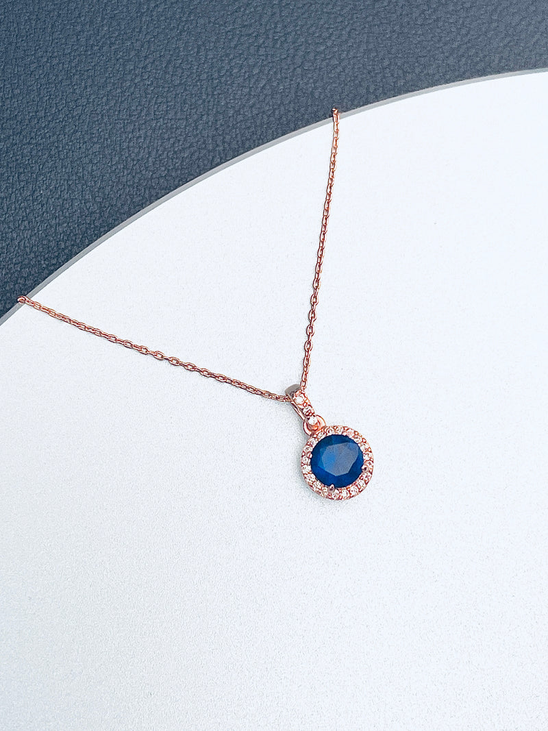 ZURI - Pendant With Round Sapphire Blue CZ In A Delicate Setting In Rose Gold - JohnnyB Jewelry